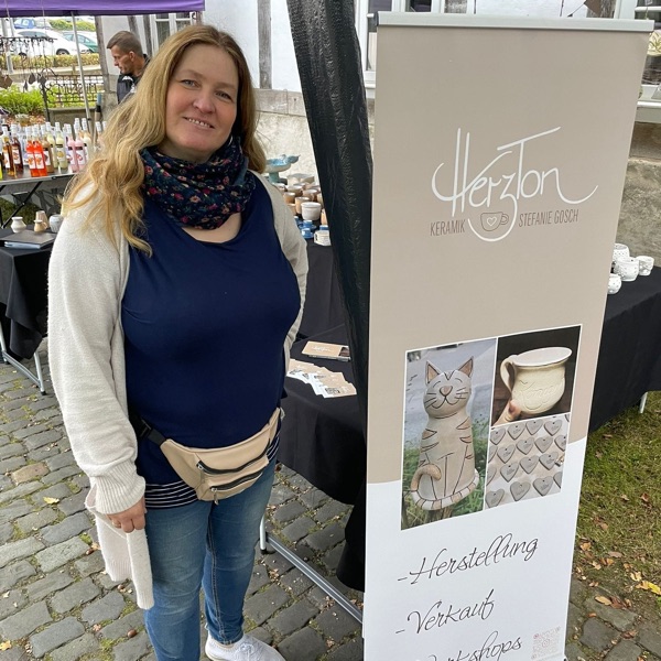 Steffi an ihrem Marktstand mit dem HerzTon-Banner