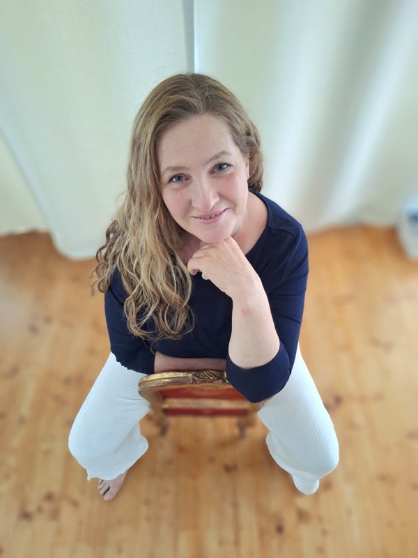 Steffi lächelt, auf einem goldenen Stuhl sitzend