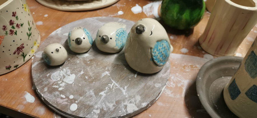 Drei kleine Vogelfiguren mit gemustertem Gefieder in Blau und Grün